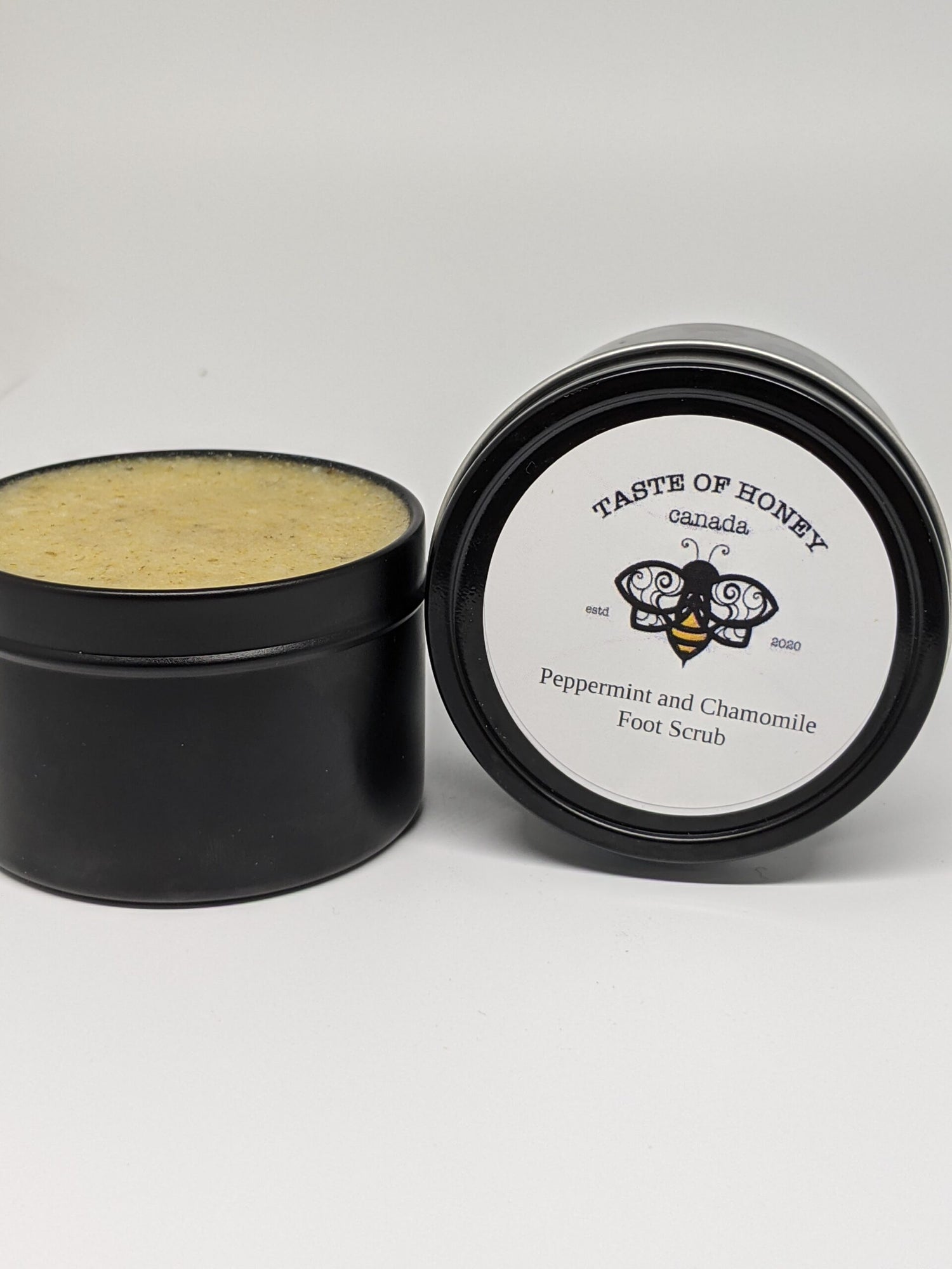 Peppermint and Chamomile Foot scrub.  Black tin white label with bee logo.  Deep yellow color product