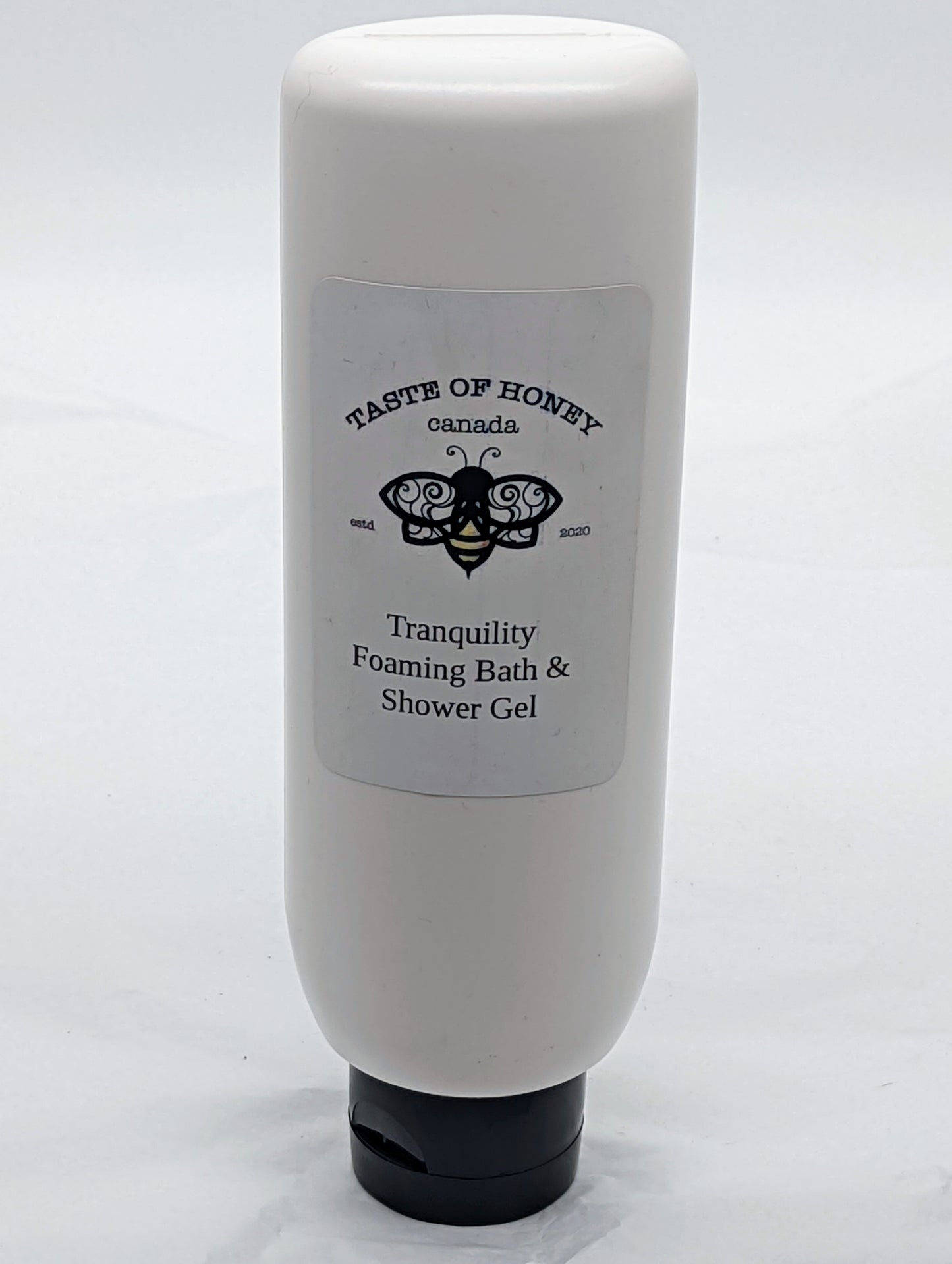 Tranquility Foaming Bath and Shower Gel.  With bottle with black lid.  Bee logo with Taste of Honey Canada.  